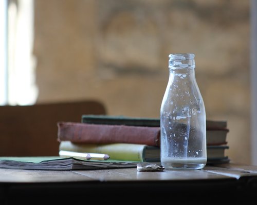 Glass of water next to an open notebook on a desk